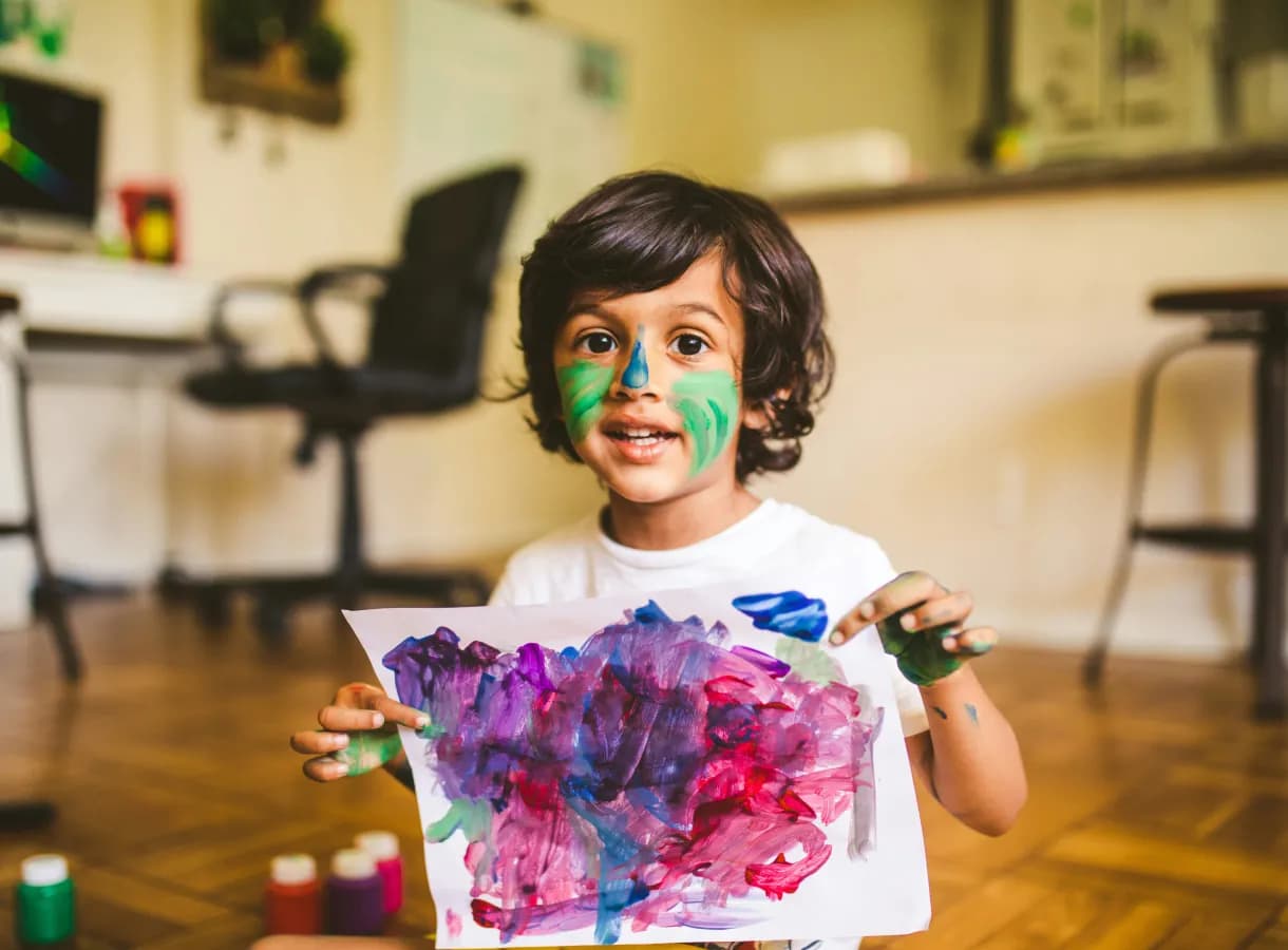 Child holding up a colourful painting